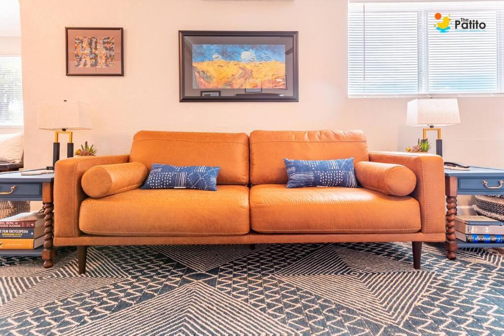 an orange couch sitting in a living room at The Patito: Walk to the Zoo, Cafes and Restaurants in Albuquerque