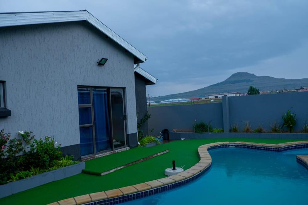 a yard with a swimming pool and a house at K4 Bed and Breakfast in Maseru