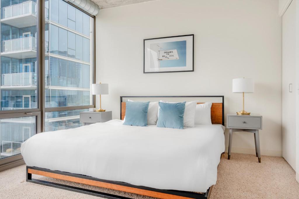 - une chambre avec un grand lit et une grande fenêtre dans l'établissement Kasa South Loop Chicago, à Chicago