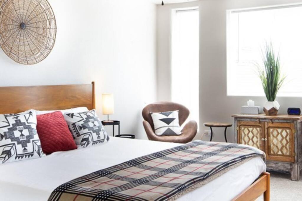 ein Schlafzimmer mit einem Bett und einem Stuhl in der Unterkunft The Lagartija @ Old Town with King Bed in Albuquerque