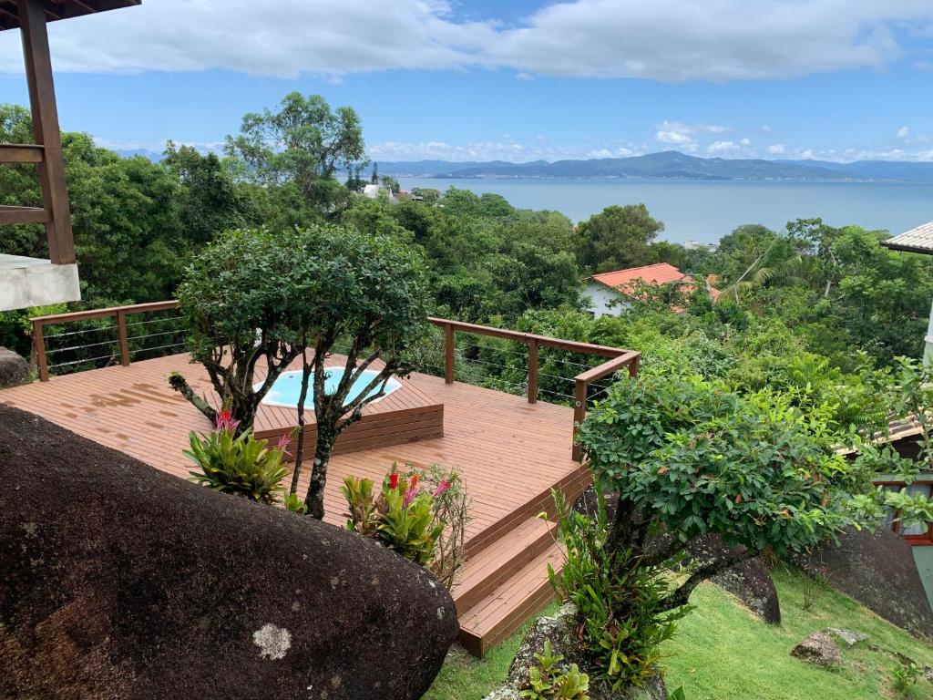 a wooden deck with a view of the water at Sunset Cacupé in Florianópolis