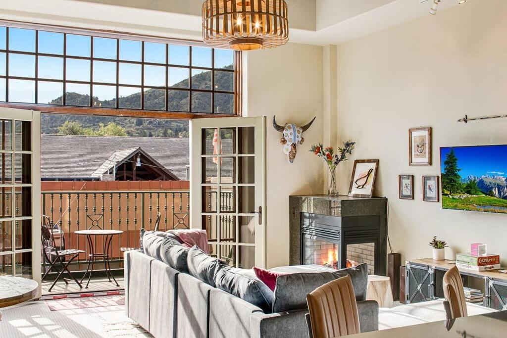 a living room with a couch and a fireplace at The Owl's Nest @ Manitou: Mtn Views on Main Street in Manitou Springs