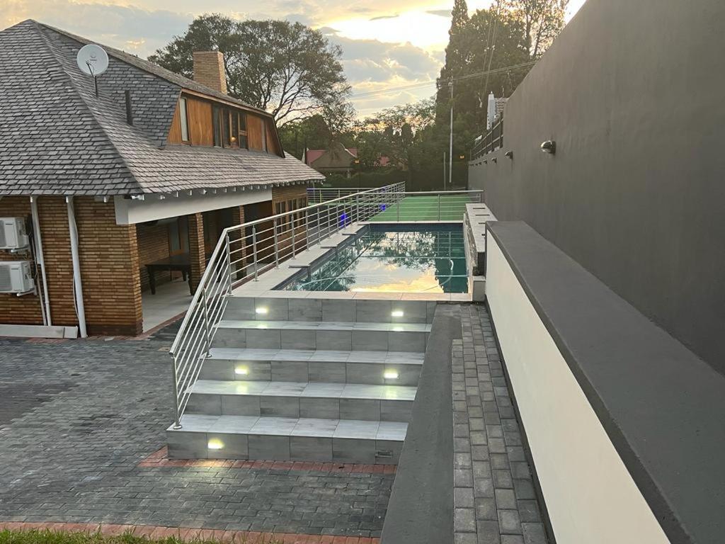 a staircase leading to a house with a swimming pool at Liso’s Place Guest House in Pretoria