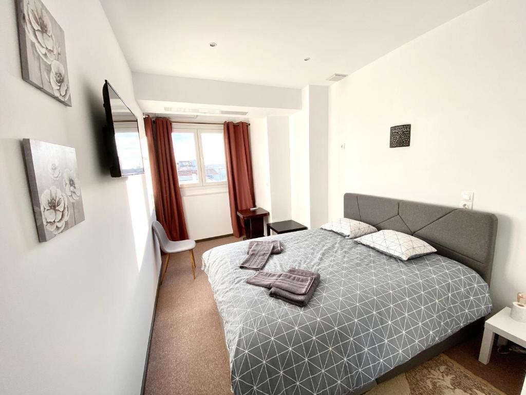 sypialnia z szarym łóżkiem i oknem w obiekcie Classic 2 Bedroom Apartment Next to Metro - Marousi w Atenach