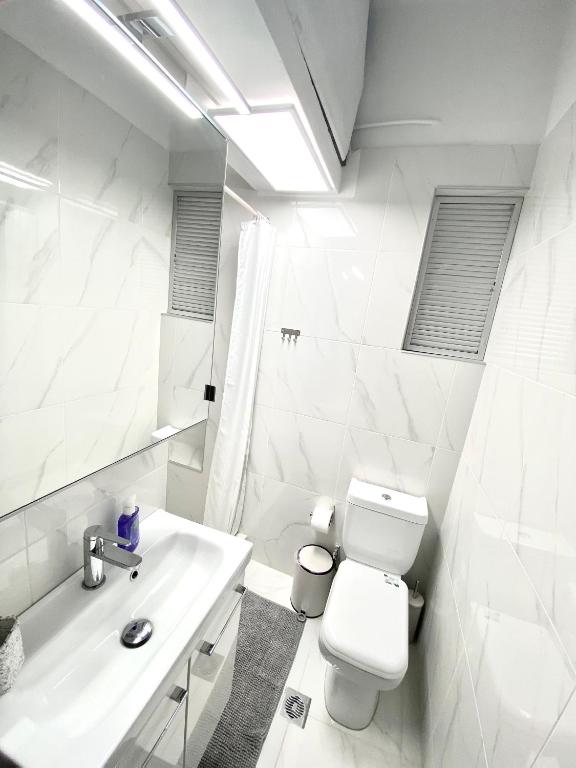 biała łazienka z toaletą i umywalką w obiekcie Classic 2 Bedroom Apartment Next to Metro - Marousi w Atenach
