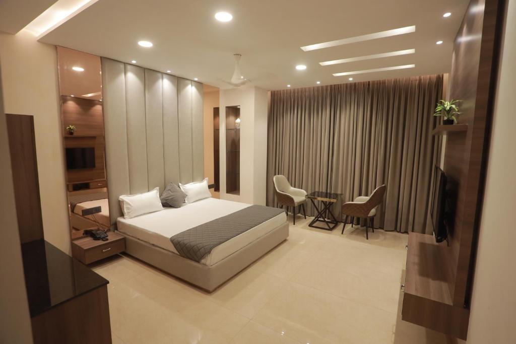 um quarto com uma cama, uma mesa e cadeiras em OVEL HOTEL (LUXURY) em Ludhiana