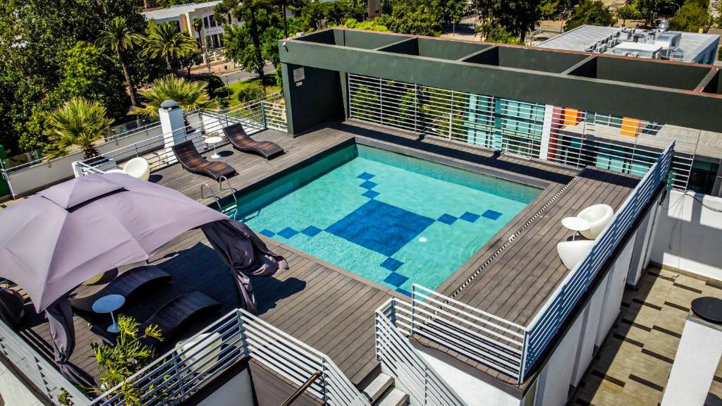 an overhead view of a swimming pool with an umbrella at Ecohotel Talca in Talca