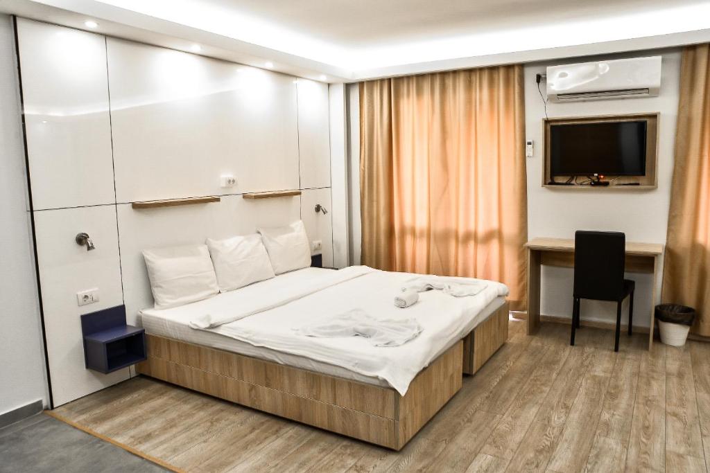 a bedroom with a bed and a desk and a television at Villa ARS in Belgrade