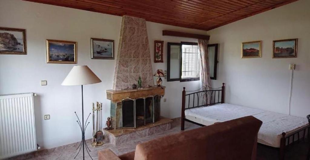 a living room with a fireplace and a couch at Villa Mira in Rizómilos