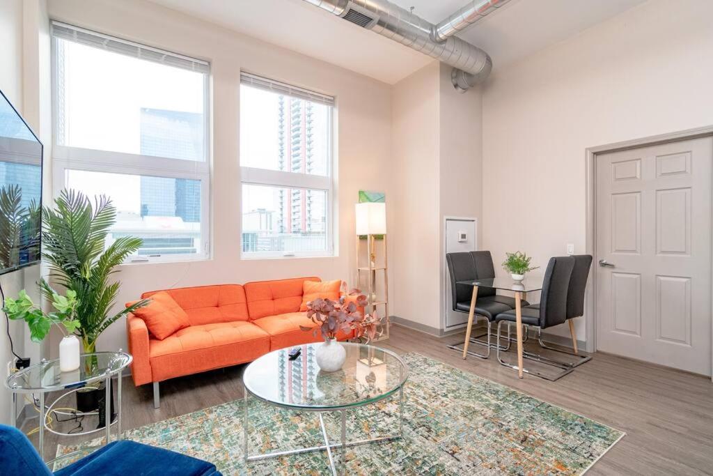 ein Wohnzimmer mit einem orangenen Sofa und einem Tisch in der Unterkunft McCormick Place 2br-2ba with Optional Parking, Patio, Gym access for 6 guests in Chicago