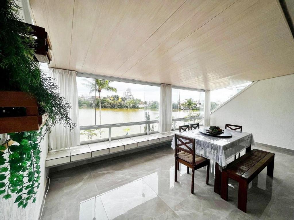a dining room with a table and chairs and a large window at Estada inesquecível 11 Guarapari/Peracanga-Bacutia in Guarapari