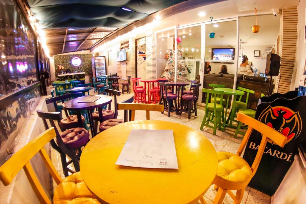 un ristorante con tavolo giallo e sedie colorate di Urbana Hostel a Bogotá