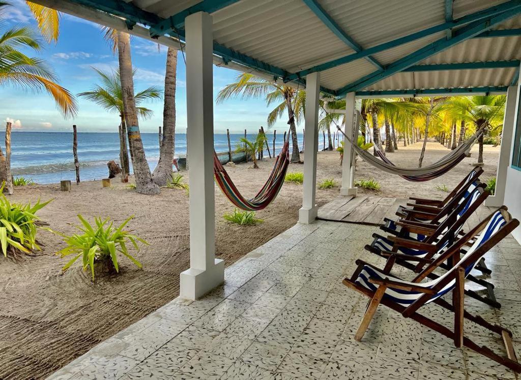 een groep stoelen en hangmatten op het strand bij Casa Manglar in Tolú