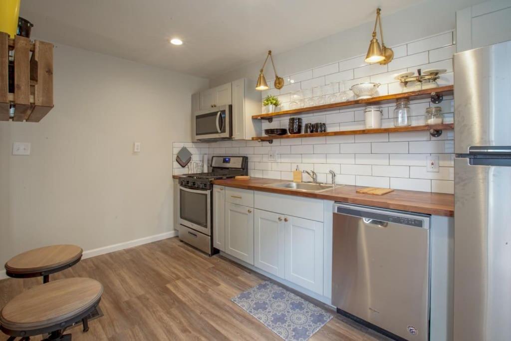 ピッツバーグにあるBeautiful One Bedroom City Oasisの白い家電製品が備わるウッドフロアのキッチン