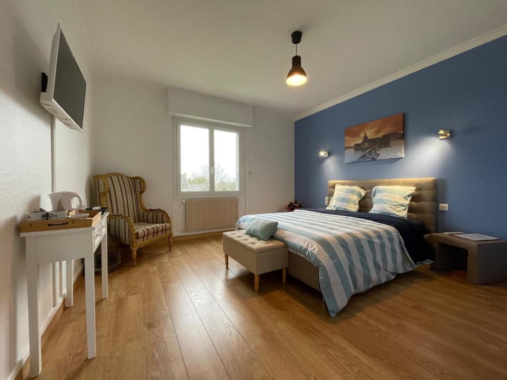 - une chambre avec des murs bleus et un lit avec un bureau dans l'établissement Chez Tib, à Trégunc