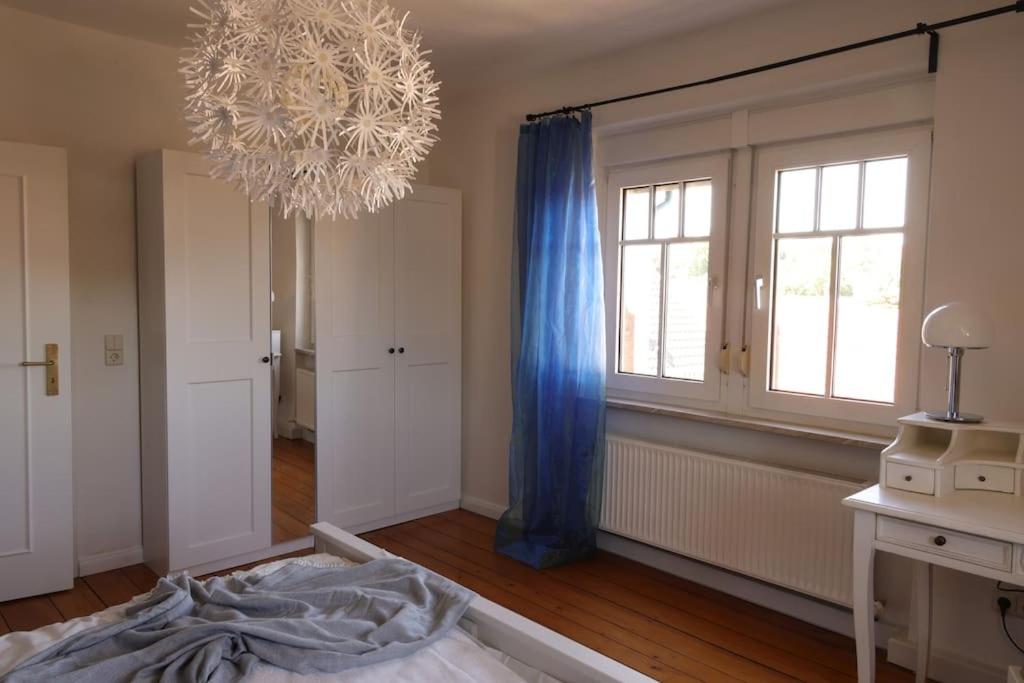 een slaapkamer met een bed en een kroonluchter bij Charmante, großzügige Ferienwohnung Villa Fleurie in Bretten