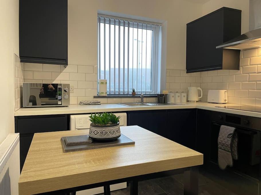 a kitchen with a table with a plant on it at Modern Apartment With En-suite & Private Kitchen in Stoke on Trent