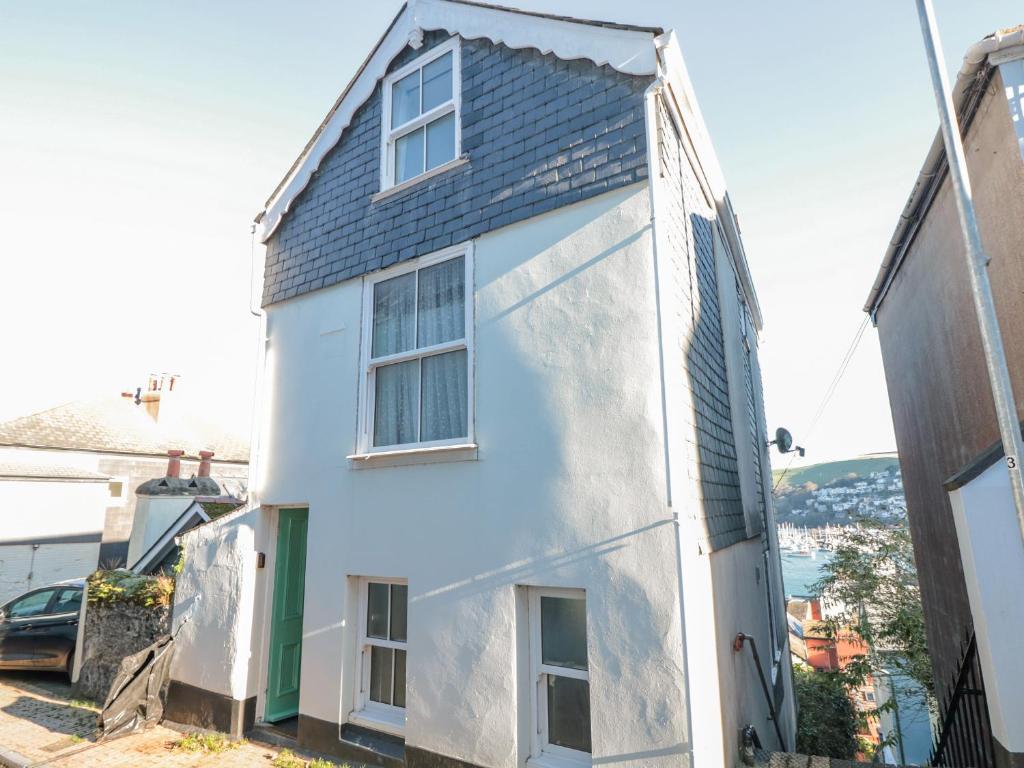 a white house with a blue roof at 19 Above Town in Dartmouth