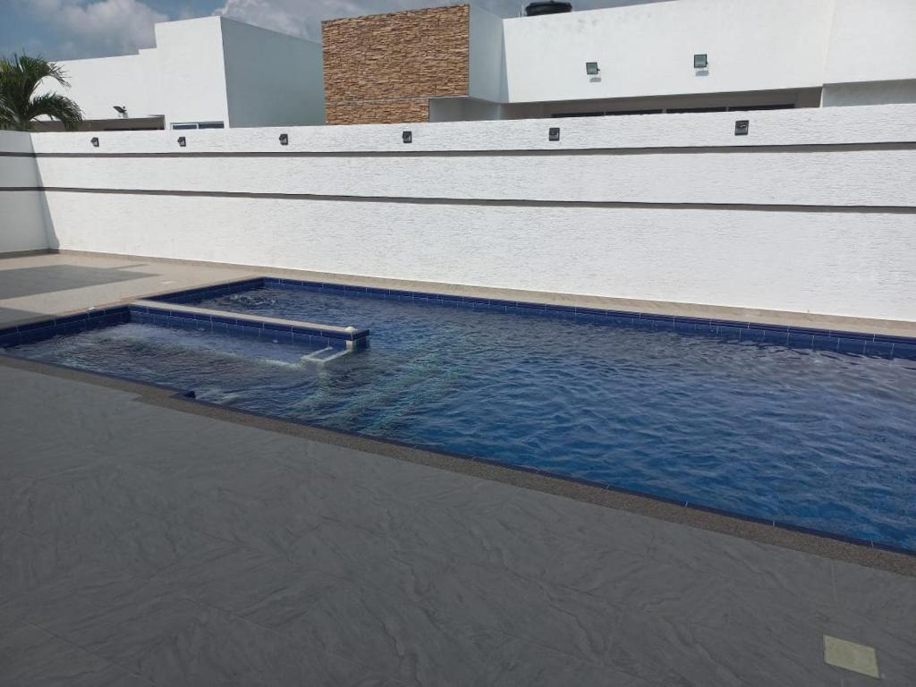 una piscina de agua junto a un edificio en Casa Quinta piscina privada y jacuzzi en cercanías a Girardot, en Girardot