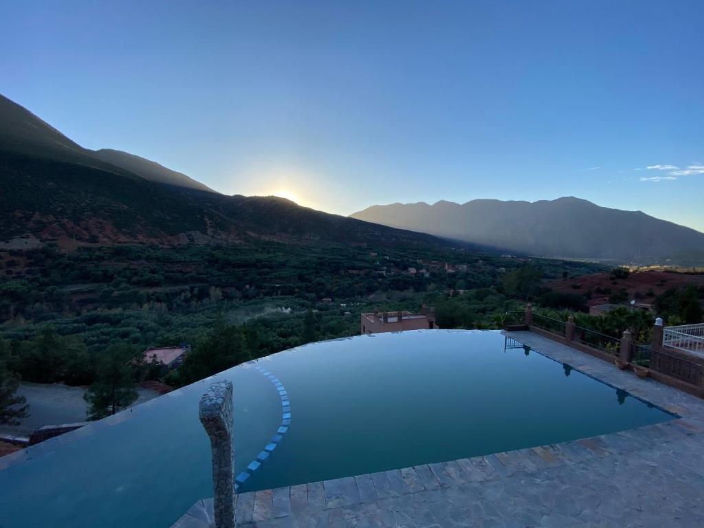 a large swimming pool with mountains in the background at KASBAH LA DAME BIJA in Tassa Ouirgane
