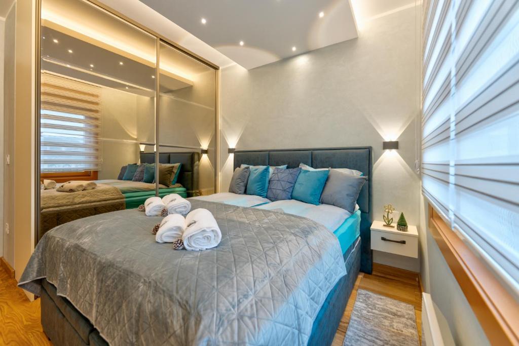 a bedroom with a large bed with towels on it at Apartman Lux M&B 2 in Zlatibor