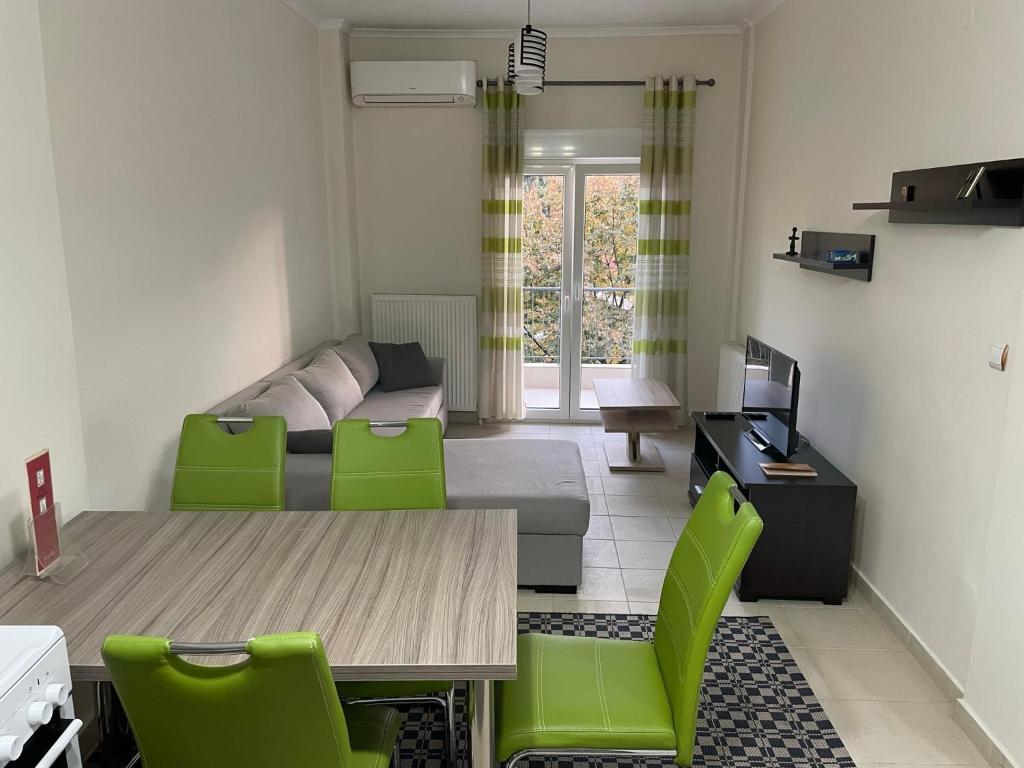een woonkamer met een tafel en groene stoelen bij Νέο διαμέρισμα πολυκατοικίας σε ιστορικό κέντρο in Thessaloniki