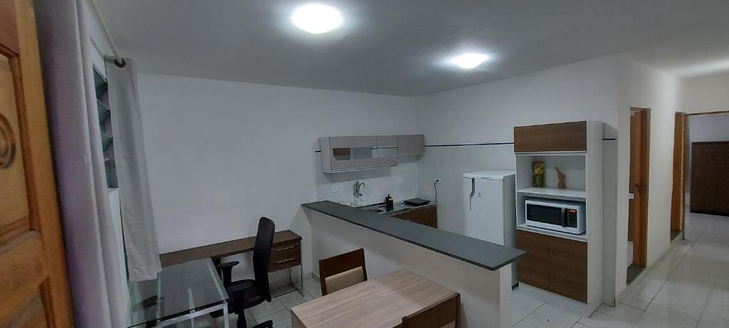 a small kitchen with a counter top and a stove top oven at Casa de Hóspedes em Parque Pinheiros - Sem Garagem in Taboão da Serra