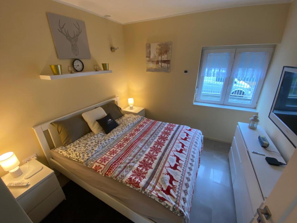 ein kleines Schlafzimmer mit einem Bett und einem Fenster in der Unterkunft Nemes Apartmanház Tóalmás in Tóalmás