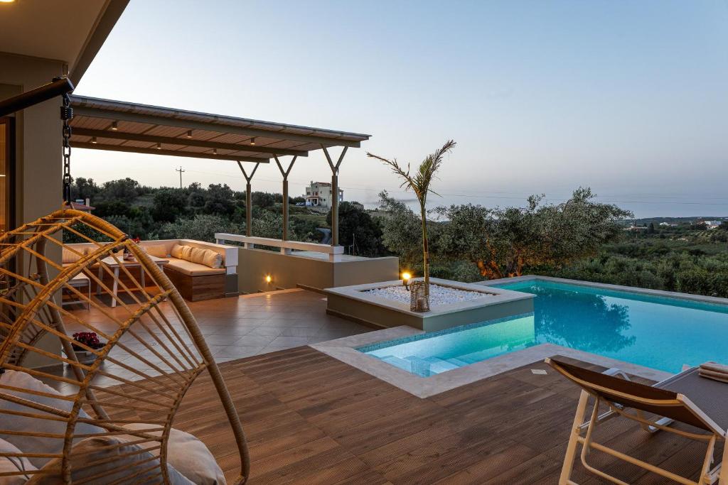 a villa with a swimming pool and a patio at Rizes Villa with Jazuzzi & Heated Pool in Agia Triada
