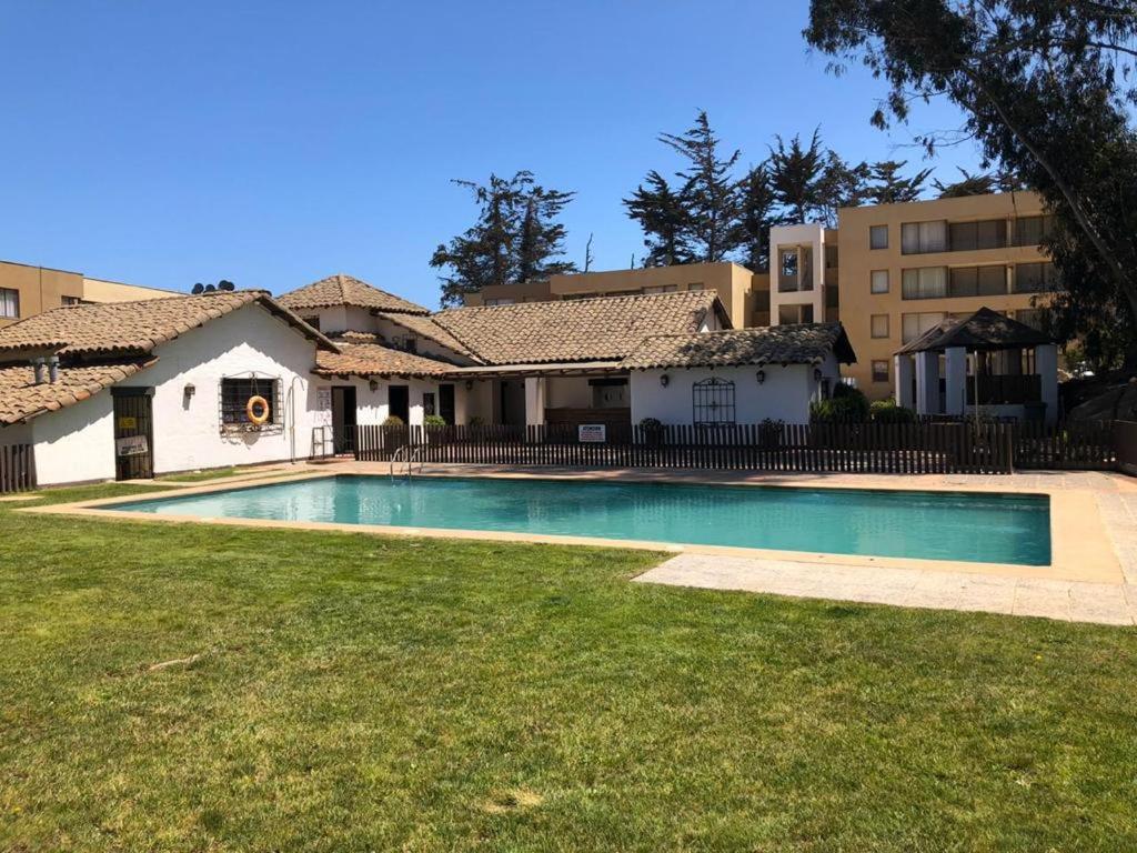 ein Haus mit einem Swimmingpool im Hof in der Unterkunft Depto Condominio La Casona in El Quisco
