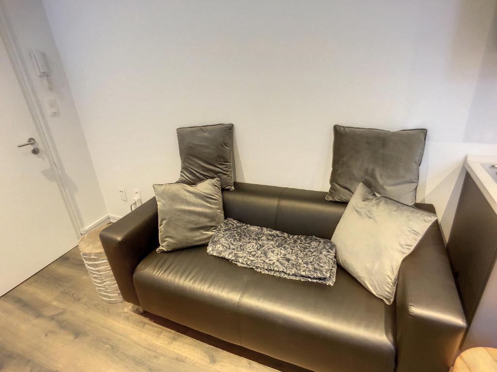 un sofá de cuero marrón en una habitación con almohadas en Appartement 003, en Angleur