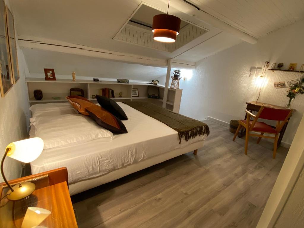 une chambre avec un grand lit blanc et un bureau dans l'établissement Les Cosy De Nancy - Le Duplex Vintage 4*, à Nancy