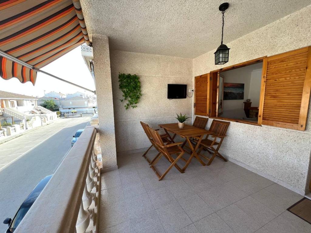 eine Terrasse mit einem Tisch und Stühlen auf dem Balkon in der Unterkunft Acogedor apartamento a escasos metros de la playa in Santa Pola