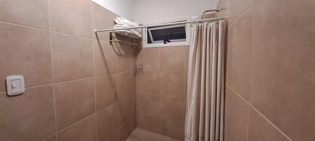 baño con ducha con ventana y cortina de ducha en Departamento con patio en Godoy Cruz