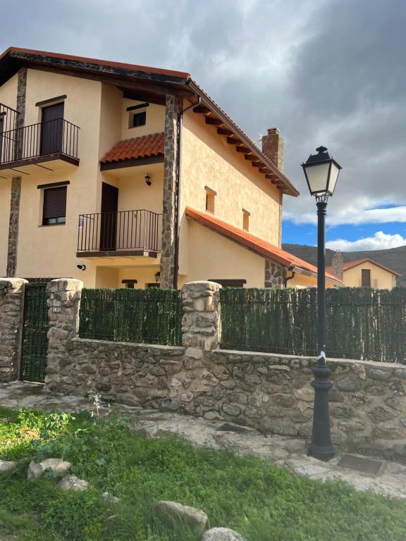 a street light in front of a fence and a house at Encanto - Pinilla del Valle in Pinilla del Valle