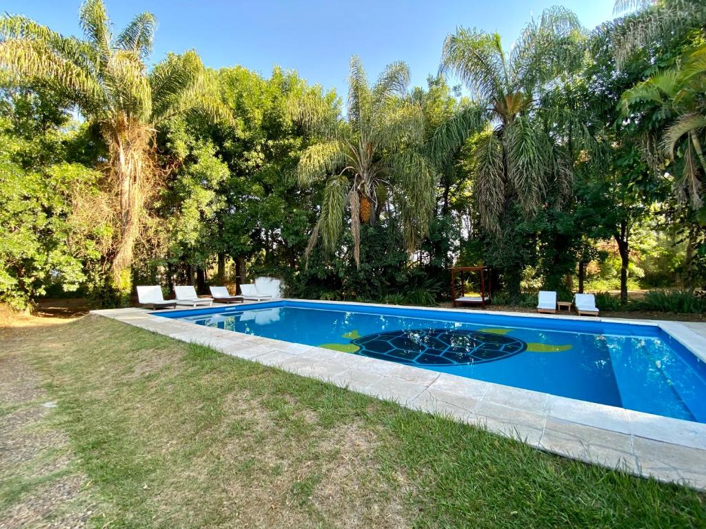 una piscina en un patio con sillas y árboles en Posada Morotí en Esquina