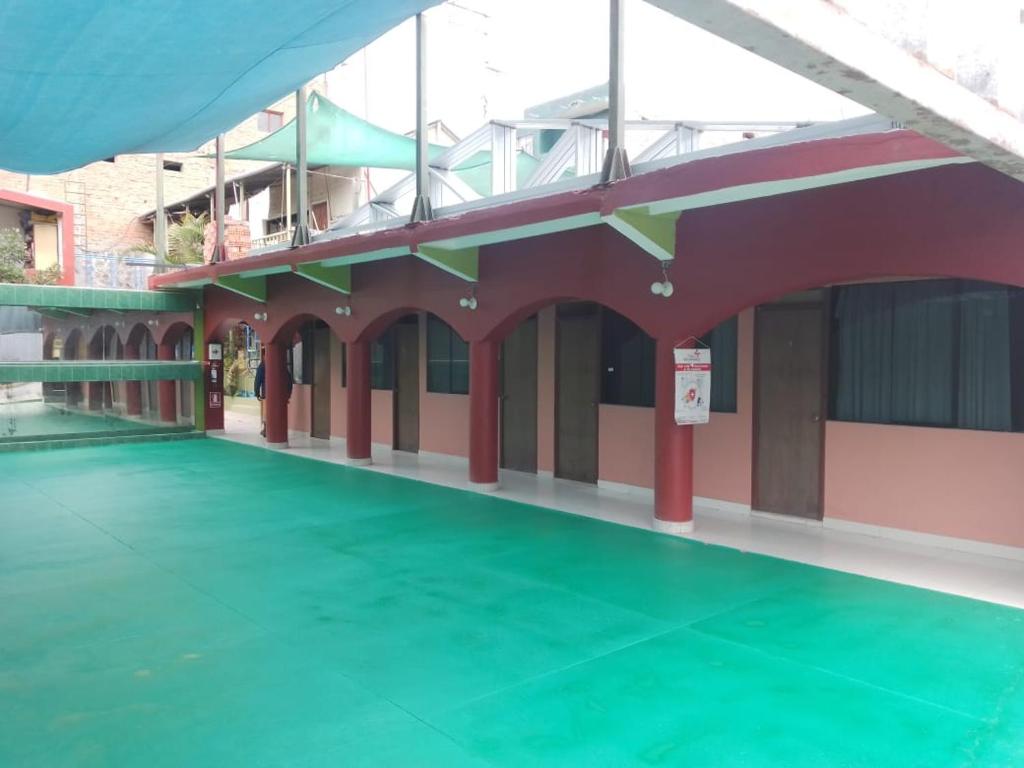 un edificio vacío con un suelo verde delante de él en Casa Hospedaje Familiar Kaleta en Mollendo