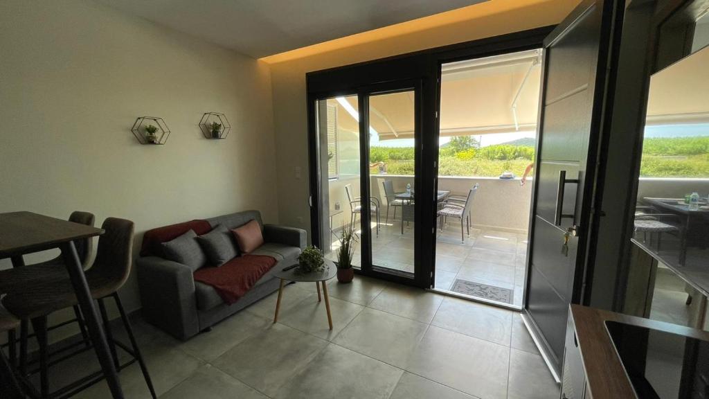 a living room with a couch and a table at Thalassa Apartment in Nea Peramos