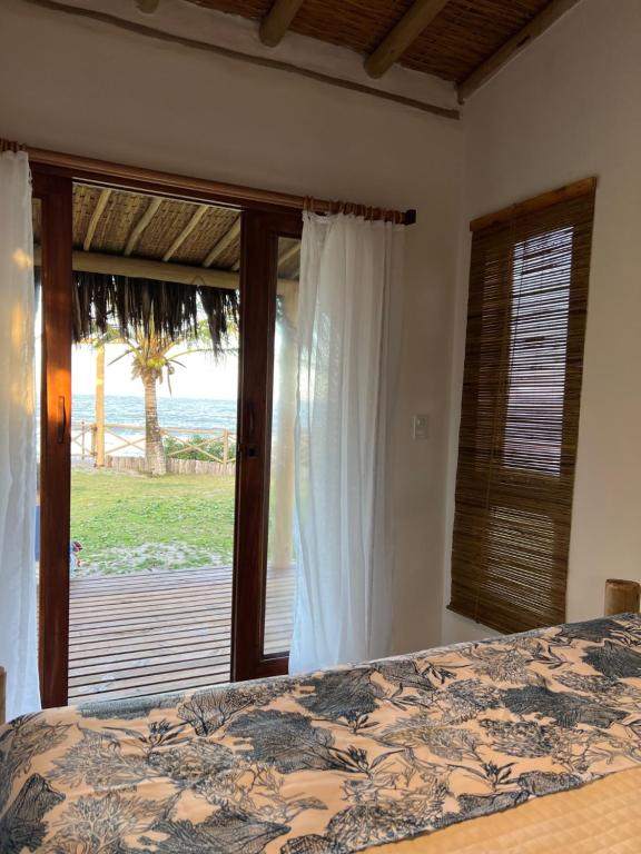 a bedroom with a bed and a view of the ocean at Vila Sereia Caraiva in Caraíva