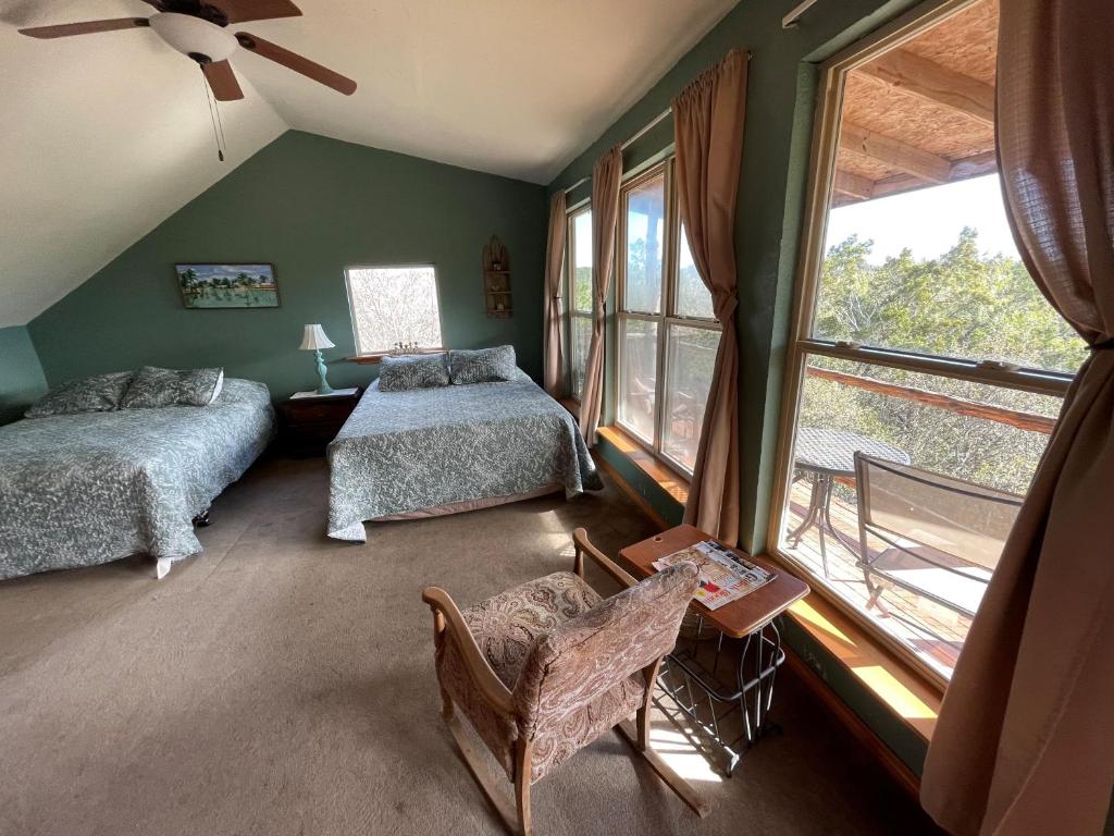 1 dormitorio con 2 camas y ventana grande en The Cedar House at Creekside Camp & Cabins, en Marble Falls