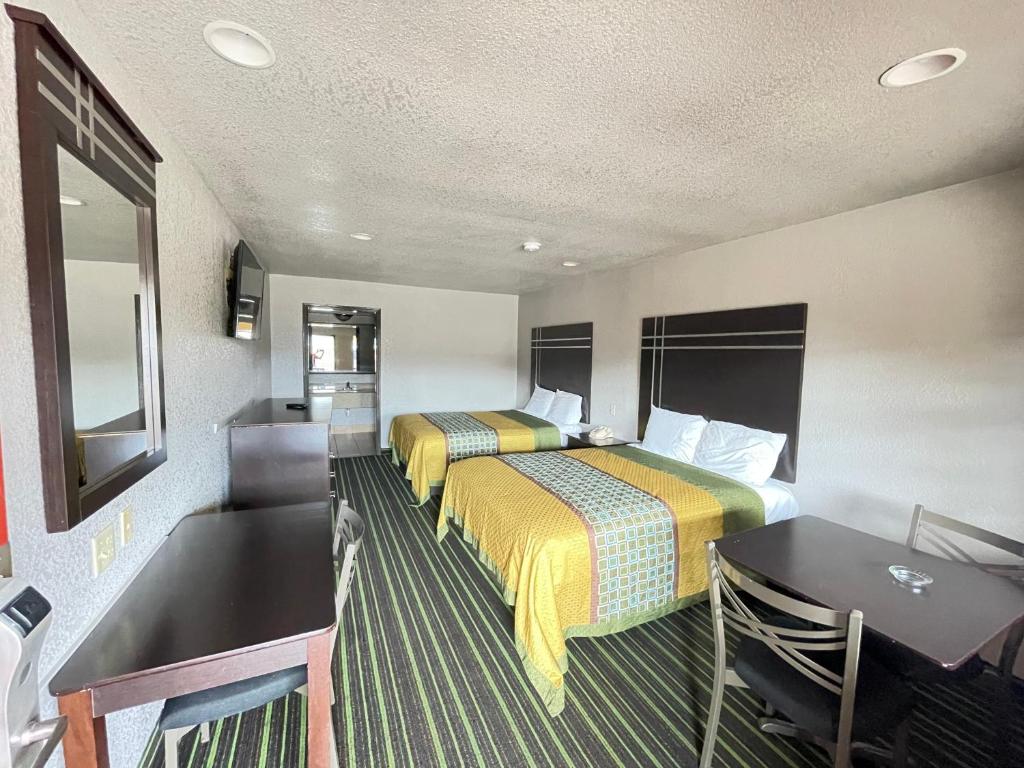 um quarto de hotel com duas camas e uma mesa em REGENCY INN - CHANNELVIEW em Channelview