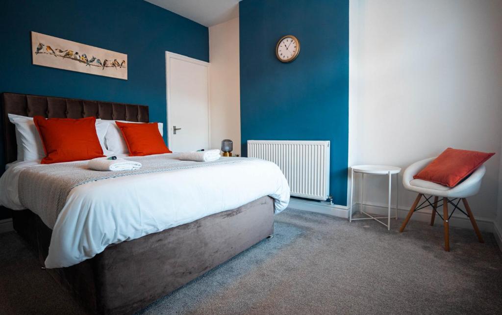1 dormitorio con 1 cama y reloj en la pared en Comfortable equipped House in Nuneaton sleeps5 with FREE parking, en Nuneaton