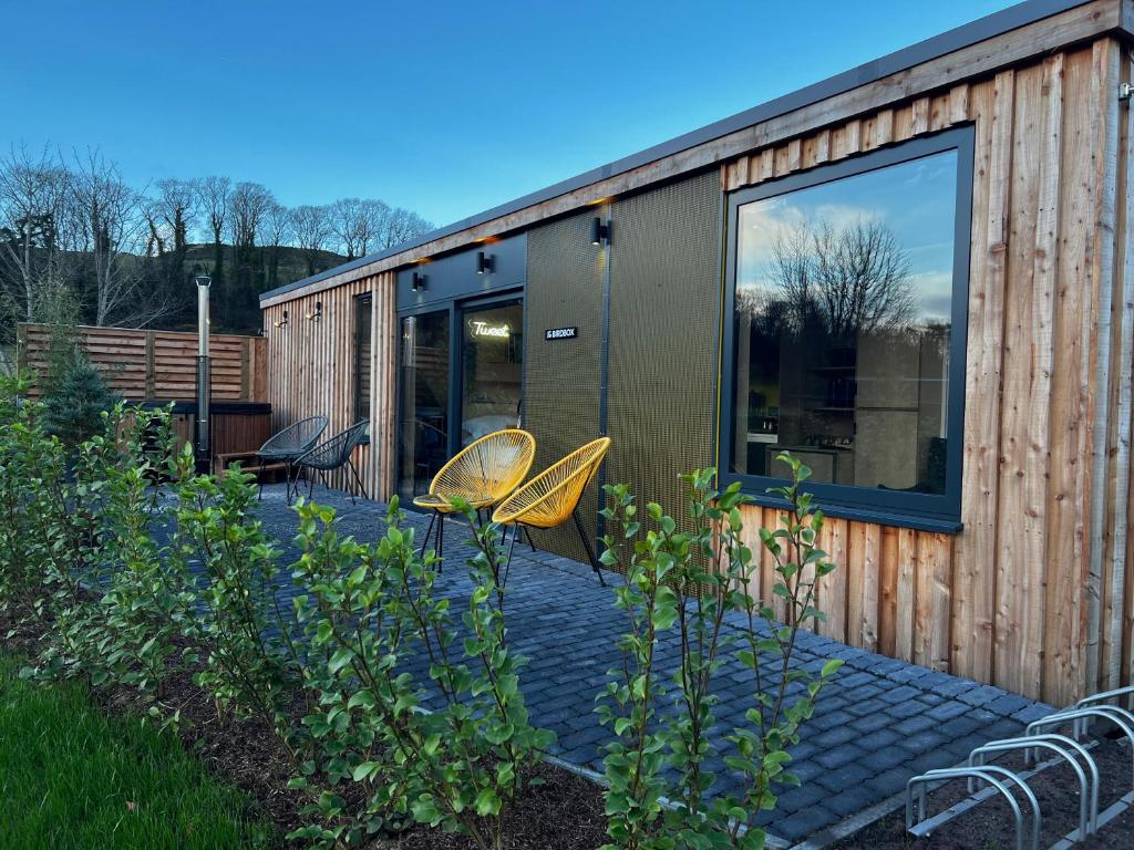 a tiny house with two chairs and a glass door at The Birdbox - Unique Cabin in Millport in Millport