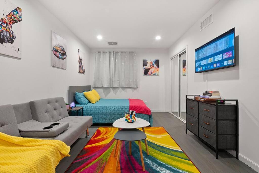 a living room with a couch and a tv at Private Studio Apartment Near NYC in Hoboken