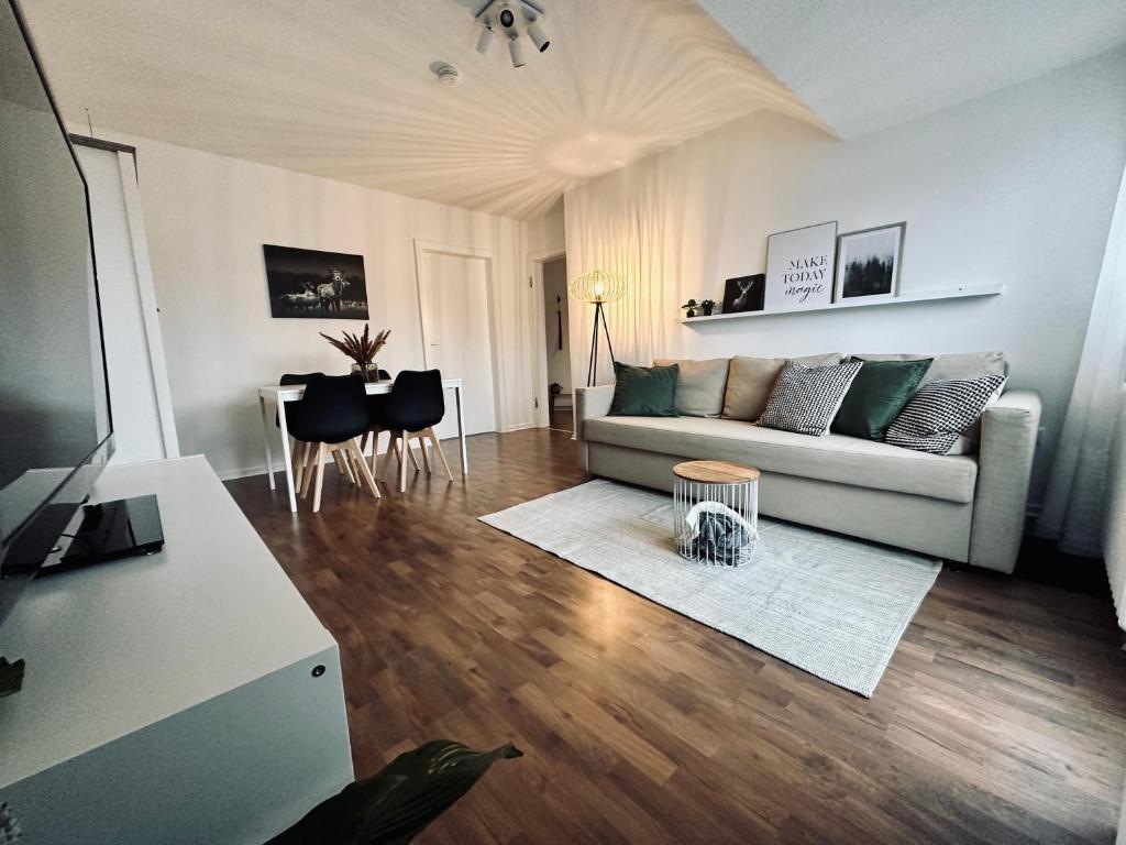 een woonkamer met een bank en een tafel bij FeWo Ruhrnatur „Modern trifft Gemütlichkeit“ in Mülheim an der Ruhr