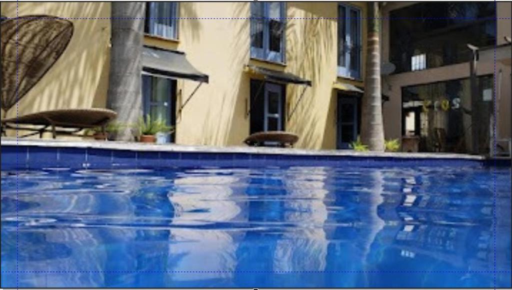 una piscina azul frente a un edificio en Pousada Santa Maria, en Tiradentes