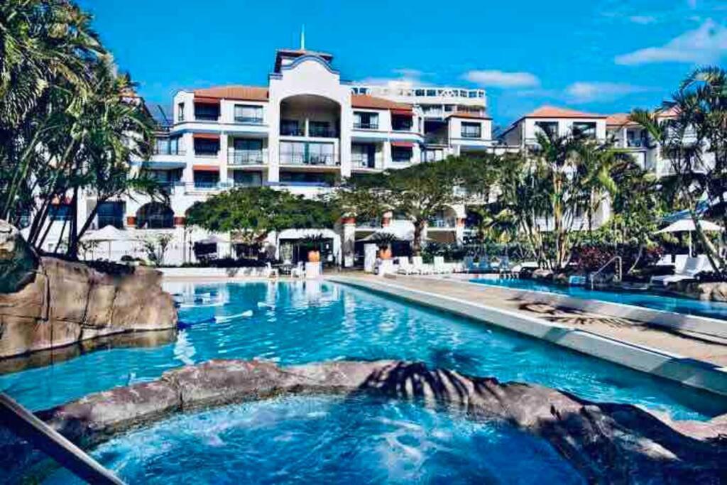 a large swimming pool in front of a resort at Gold Coast Calypso Resort, Coolangatta Beach in Gold Coast