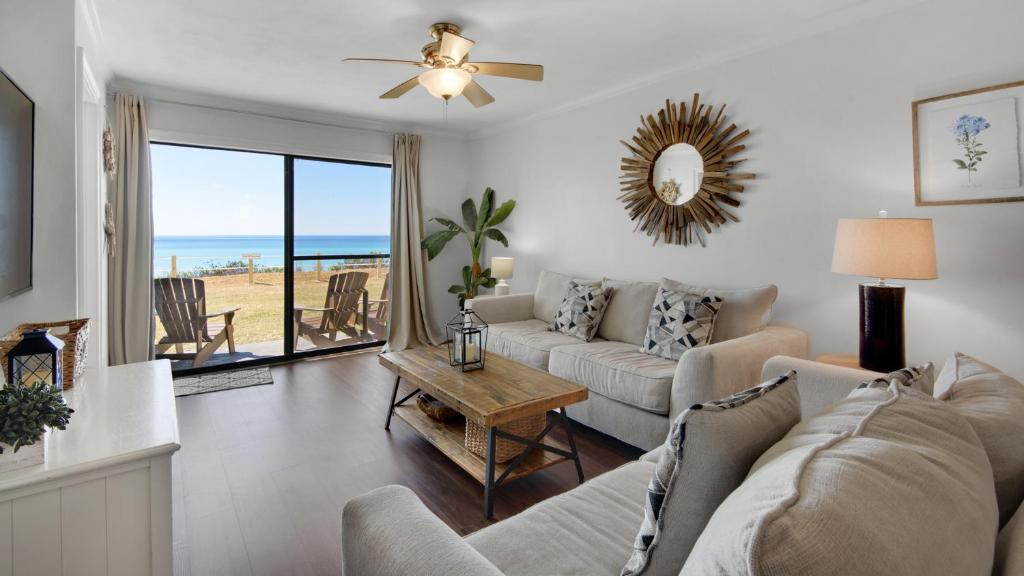 een woonkamer met een bank en een tafel bij Beachside Condo 1 in Santa Rosa Beach