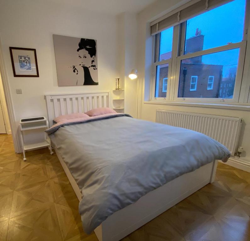 łóżko w pokoju z dużym oknem w obiekcie Spacious 1 bedroom flat in London w Londynie