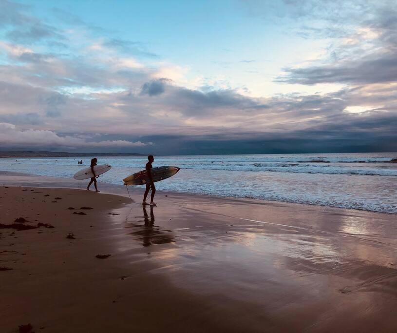 zwei Leute, die mit ihren Surfbrettern am Strand spazieren gehen in der Unterkunft U2 at Moana Beach Esplanade - Exclusive 2 Bdrm Apt - WiFi - Spa - Pet Friendly in Moana